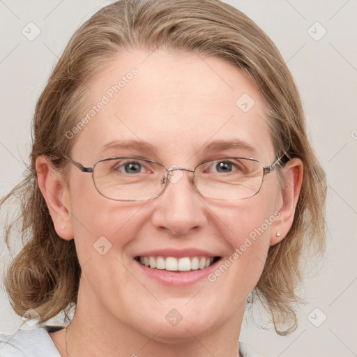 Joyful white adult female with medium  brown hair and blue eyes