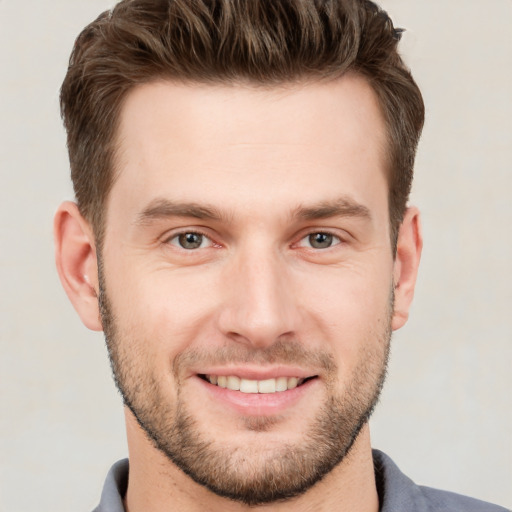 Joyful white young-adult male with short  brown hair and grey eyes