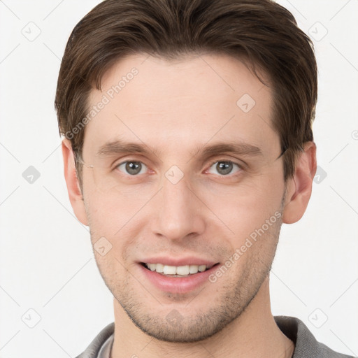 Joyful white young-adult male with short  brown hair and grey eyes