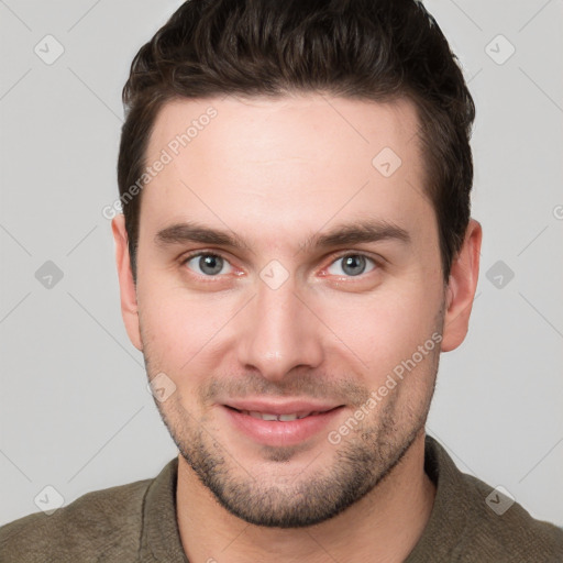 Joyful white young-adult male with short  brown hair and grey eyes