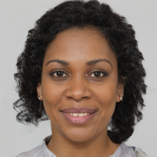 Joyful black young-adult female with medium  brown hair and brown eyes