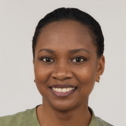 Joyful black young-adult female with short  black hair and brown eyes