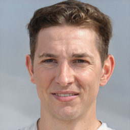 Joyful white adult male with short  brown hair and grey eyes