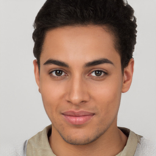 Joyful latino young-adult male with short  brown hair and brown eyes