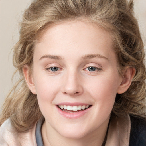 Joyful white young-adult female with medium  brown hair and blue eyes