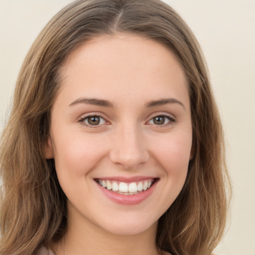 Joyful white young-adult female with long  brown hair and green eyes