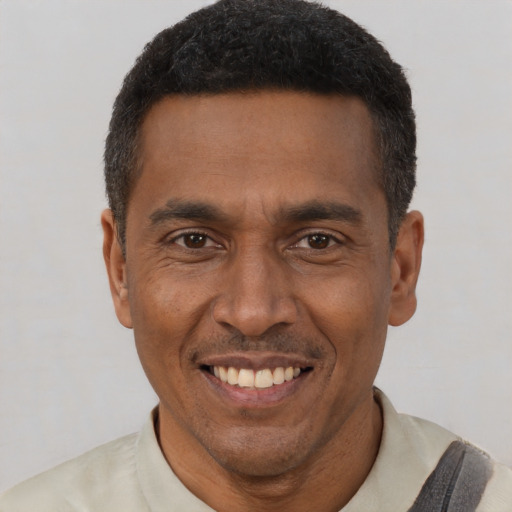Joyful black adult male with short  black hair and brown eyes