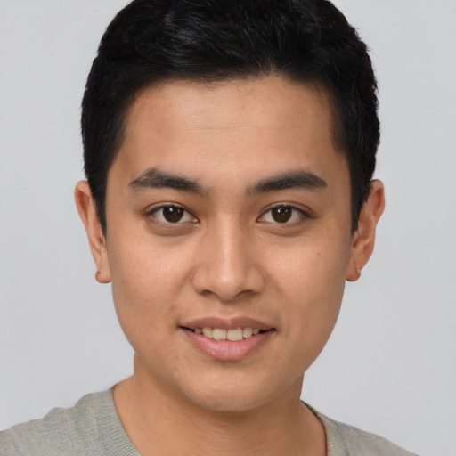 Joyful latino young-adult male with short  brown hair and brown eyes