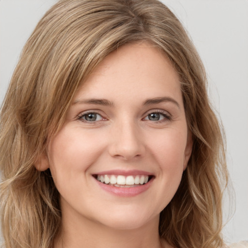 Joyful white young-adult female with long  brown hair and green eyes