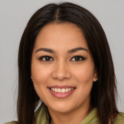 Joyful latino young-adult female with long  brown hair and brown eyes