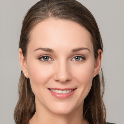 Joyful white young-adult female with medium  brown hair and grey eyes