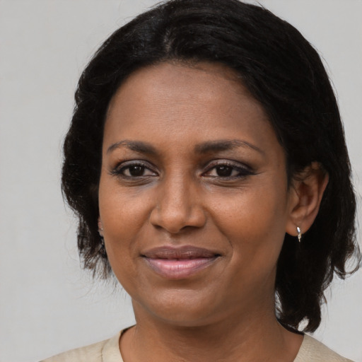 Joyful black adult female with medium  black hair and brown eyes