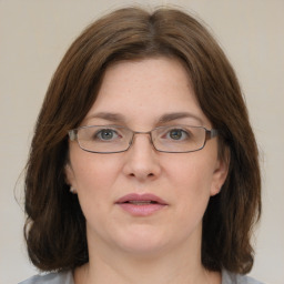 Joyful white young-adult female with medium  brown hair and green eyes