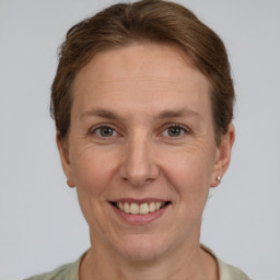 Joyful white adult female with short  brown hair and grey eyes