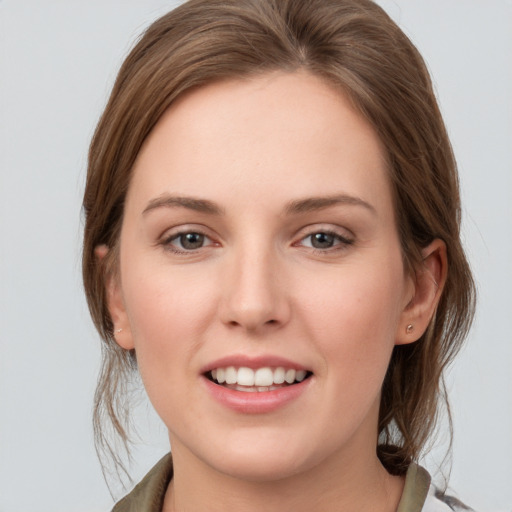 Joyful white young-adult female with medium  brown hair and grey eyes