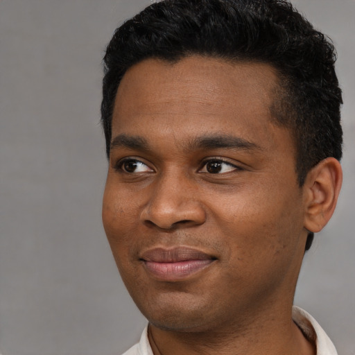 Joyful latino young-adult male with short  black hair and brown eyes