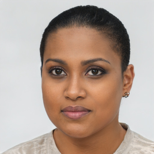 Joyful black young-adult female with short  black hair and brown eyes