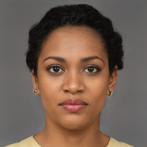 Joyful black young-adult female with short  black hair and brown eyes