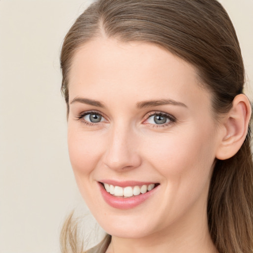 Joyful white young-adult female with long  brown hair and blue eyes