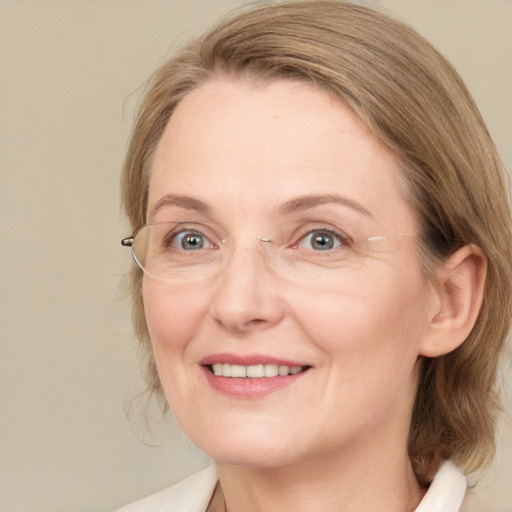 Joyful white adult female with medium  brown hair and blue eyes