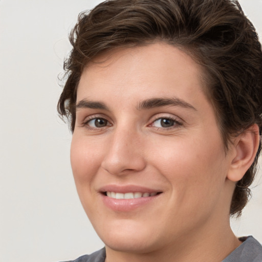 Joyful white young-adult female with short  brown hair and grey eyes