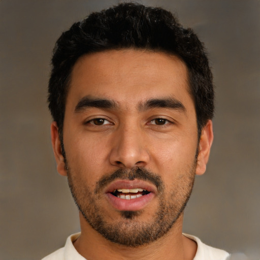 Joyful latino young-adult male with short  black hair and brown eyes
