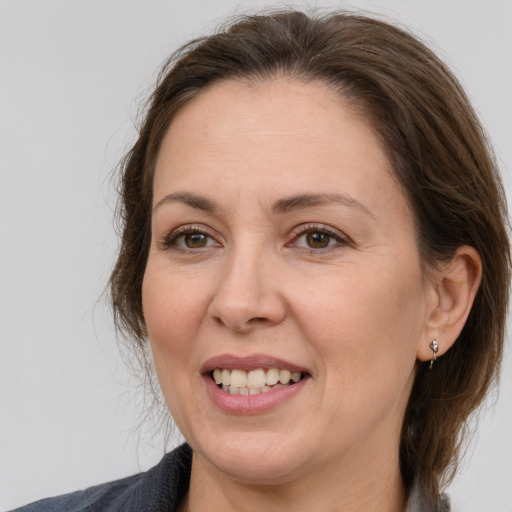 Joyful white adult female with medium  brown hair and grey eyes