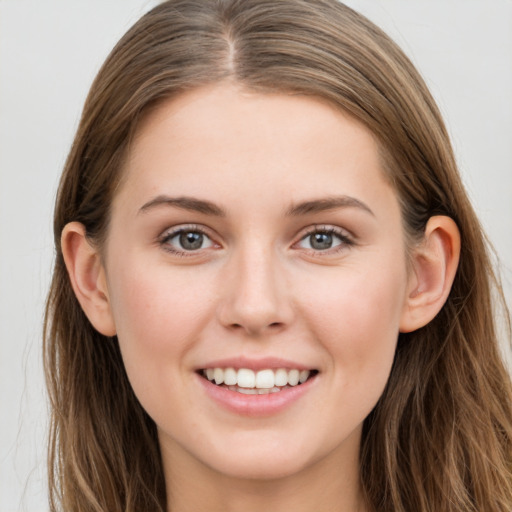 Joyful white young-adult female with long  brown hair and grey eyes