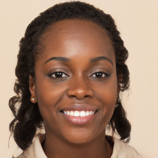 Joyful black young-adult female with long  brown hair and brown eyes