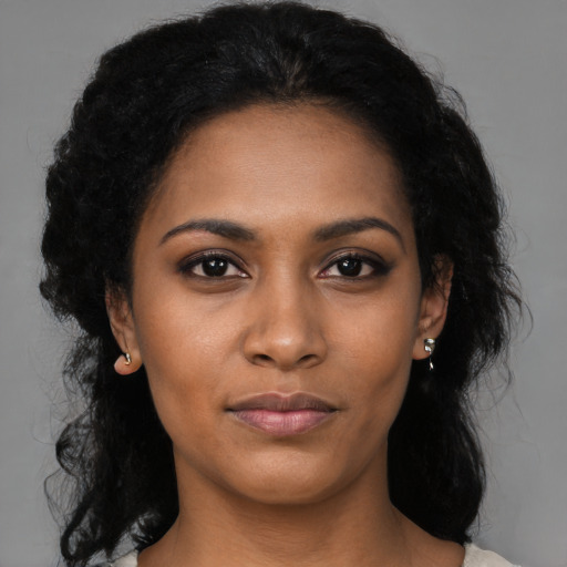 Joyful black young-adult female with long  black hair and brown eyes
