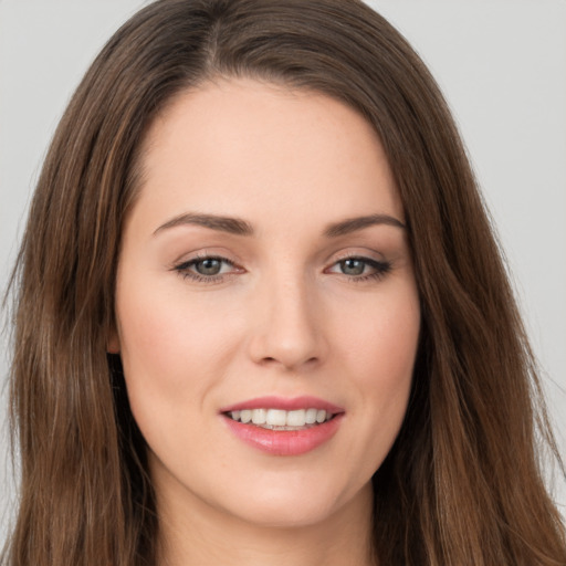 Joyful white young-adult female with long  brown hair and brown eyes