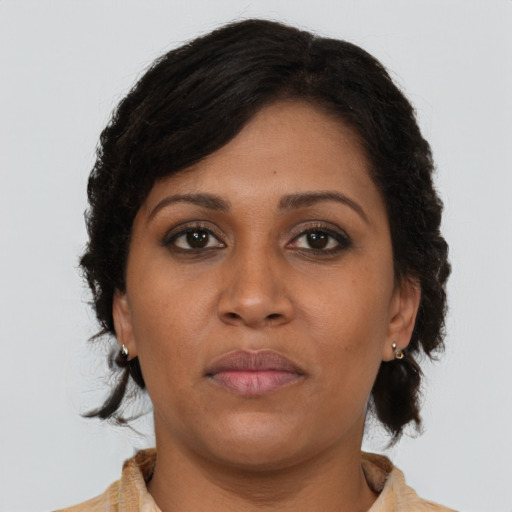 Joyful black young-adult female with medium  brown hair and brown eyes