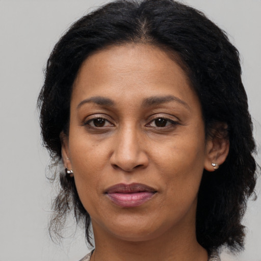 Joyful black adult female with medium  brown hair and brown eyes