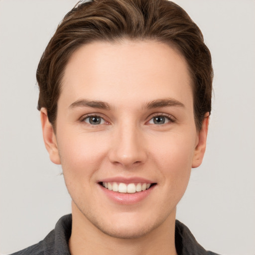 Joyful white young-adult female with short  brown hair and grey eyes