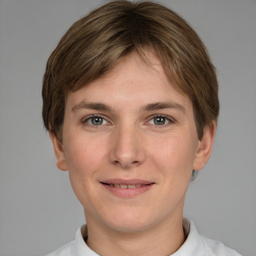 Joyful white young-adult female with short  brown hair and grey eyes