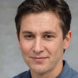 Joyful white adult male with short  brown hair and brown eyes