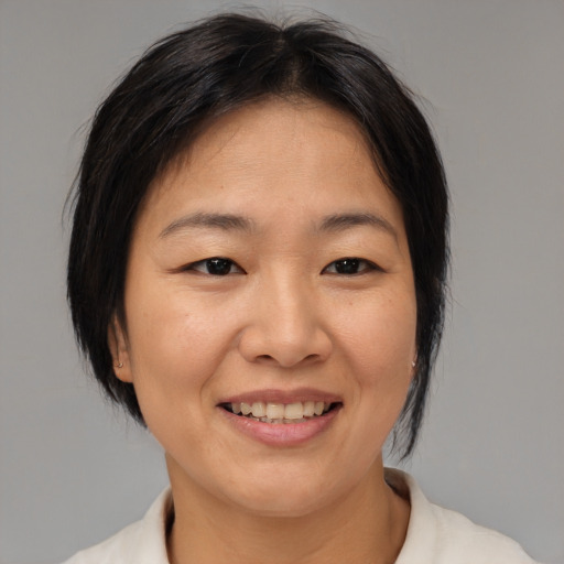 Joyful asian adult female with medium  brown hair and brown eyes