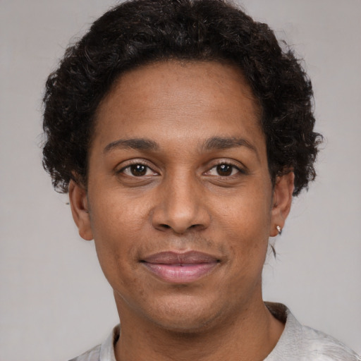 Joyful black adult female with short  brown hair and brown eyes