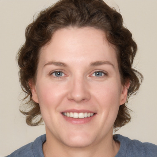 Joyful white young-adult female with medium  brown hair and blue eyes