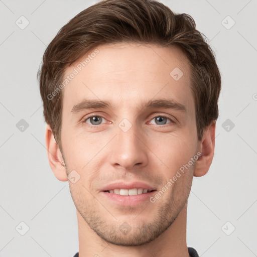 Joyful white young-adult male with short  brown hair and grey eyes