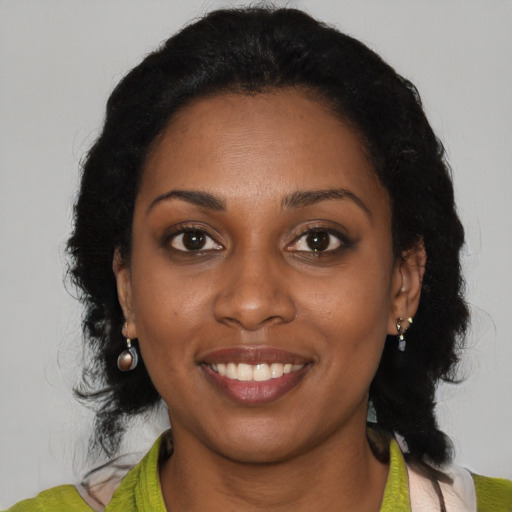 Joyful black young-adult female with medium  black hair and brown eyes