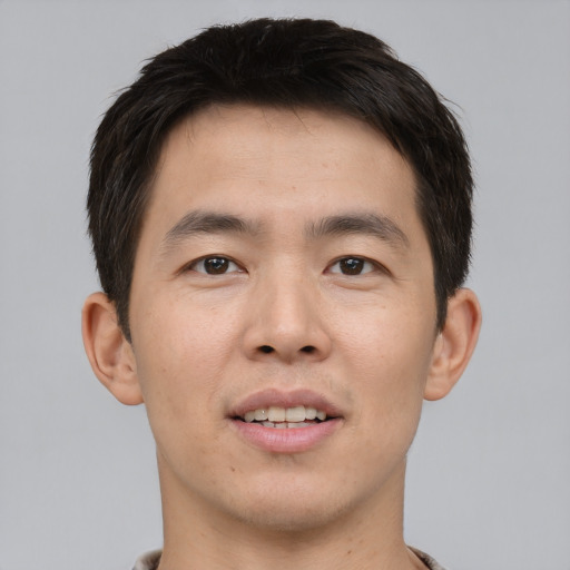 Joyful asian young-adult male with short  brown hair and brown eyes