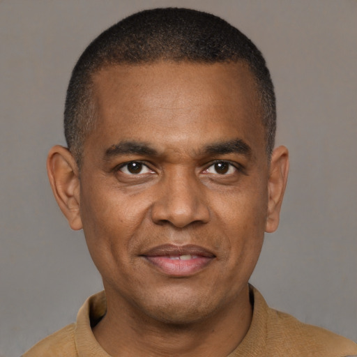 Joyful black adult male with short  black hair and brown eyes