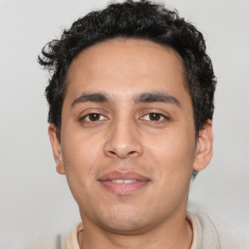 Joyful white young-adult male with short  black hair and brown eyes