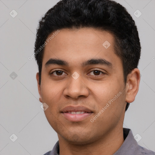 Joyful latino young-adult male with short  black hair and brown eyes