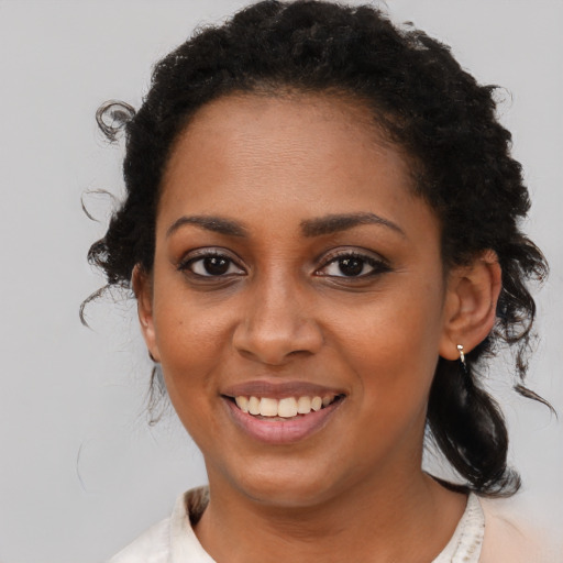 Joyful black young-adult female with medium  brown hair and brown eyes