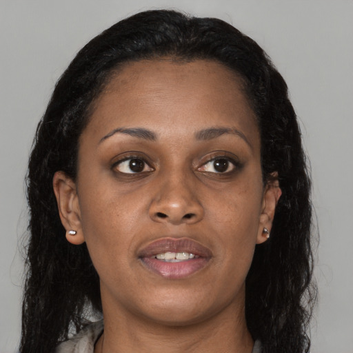 Joyful black young-adult female with long  brown hair and brown eyes