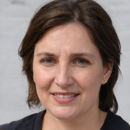 Joyful white adult female with medium  brown hair and grey eyes