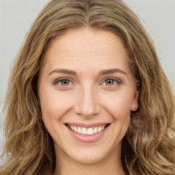 Joyful white young-adult female with long  brown hair and green eyes