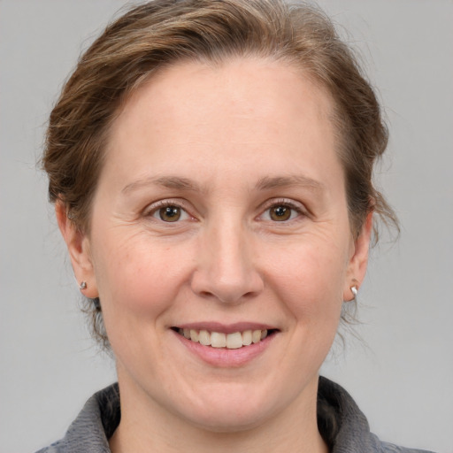 Joyful white adult female with medium  brown hair and grey eyes